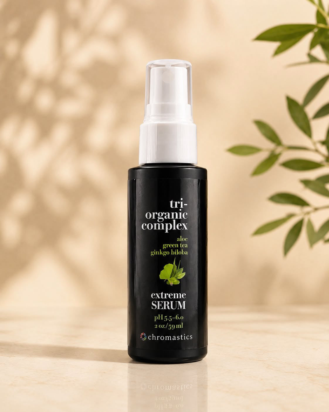 A bottle of Chromastics Tri-Organic Complex Extreme Serum, featuring a matte black bottle and a white spray nozzle, set against a warm beige background with soft leaf shadows and green leaves on the side.
