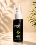 A bottle of Chromastics Tri-Organic Complex Light Serum with a white pump and clear cap, set on a marble surface with warm leaf shadows and a green plant in the background.